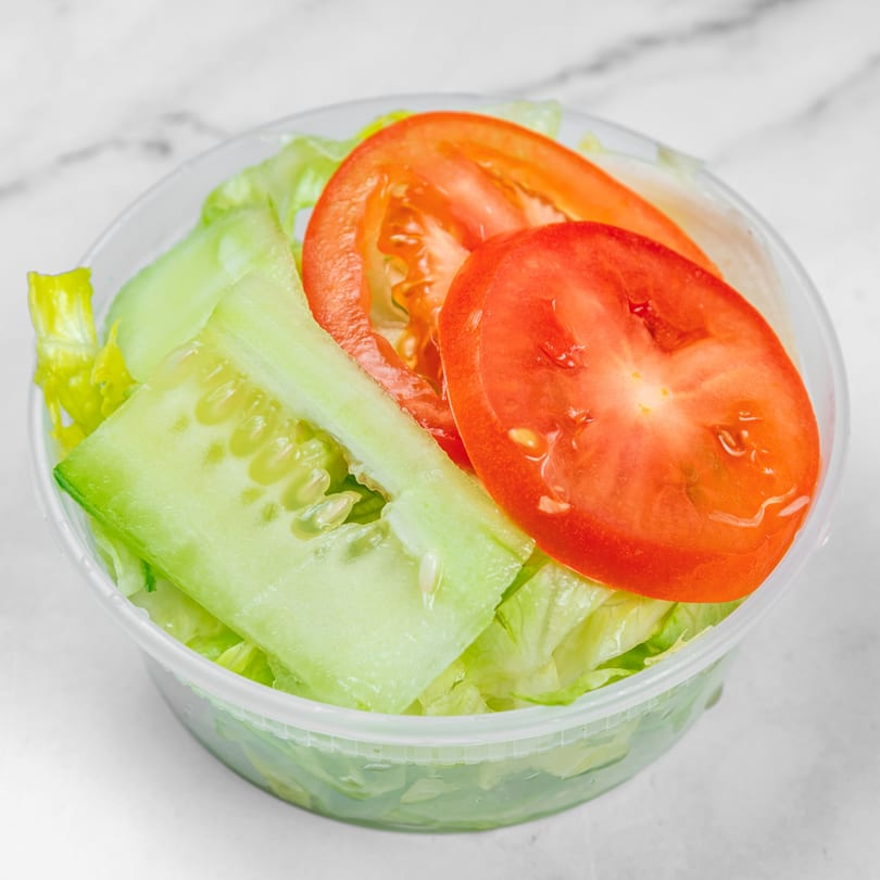 A plastic container filled with fresh green lettuce, sliced cucumbers, and red tomato wedges.
