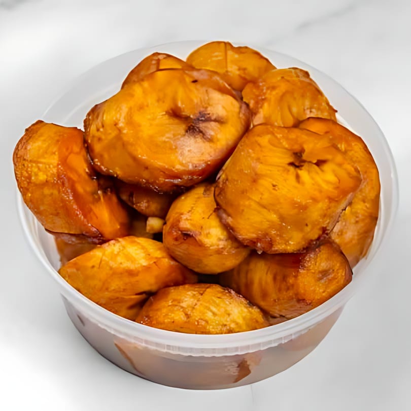 A clear plastic container filled with golden-brown, glistening fried sweet plantains, a Dominican side dish.